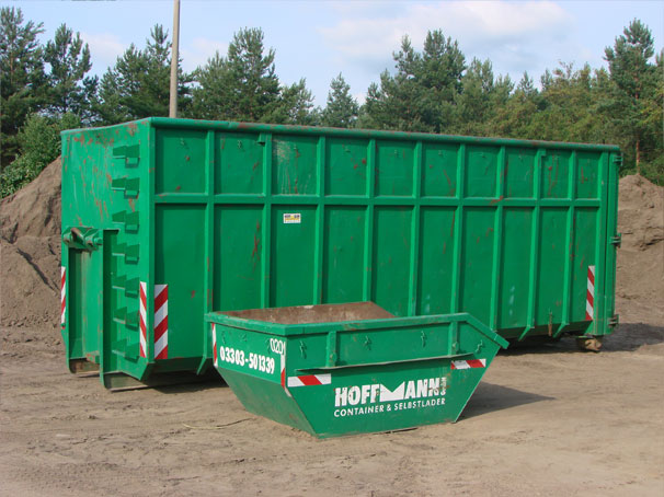 Grüner Abrollcontainer und gelbe Absetzmulde auf dem Betriebshof in Zühlsdorf